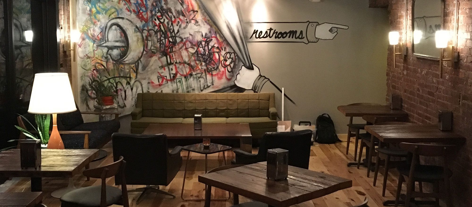 Caucho dining room with graffiti mural and exposed brick