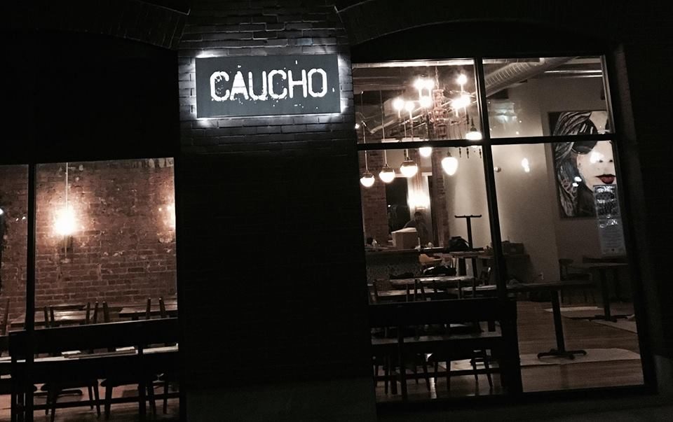 Caucho storefront at night on Third Street SE, Cedar Rapids